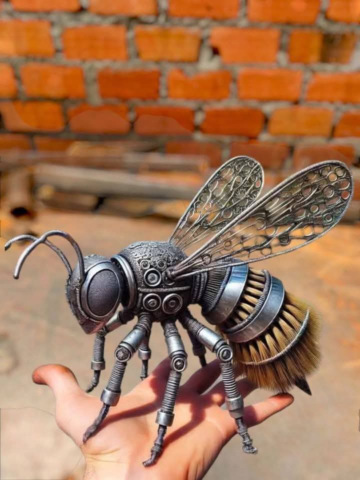 Detailed metal bee sculpture shown resting on a person's hand.