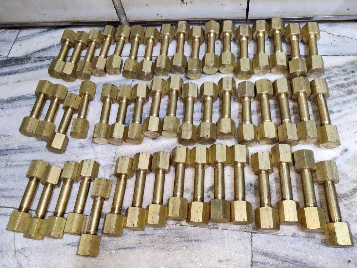 Brass-colored studs and threaded fasteners in assorted lengths