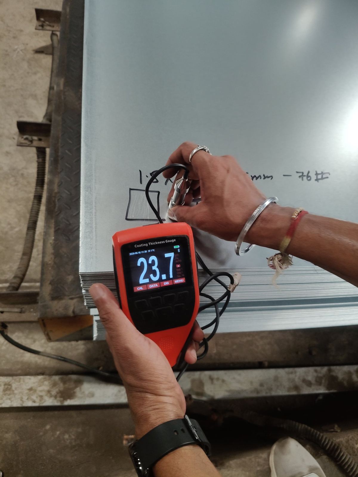 Digital coating thickness gauge measuring zinc coating on a galvanized steel sheet at Sunlite Metal Industries